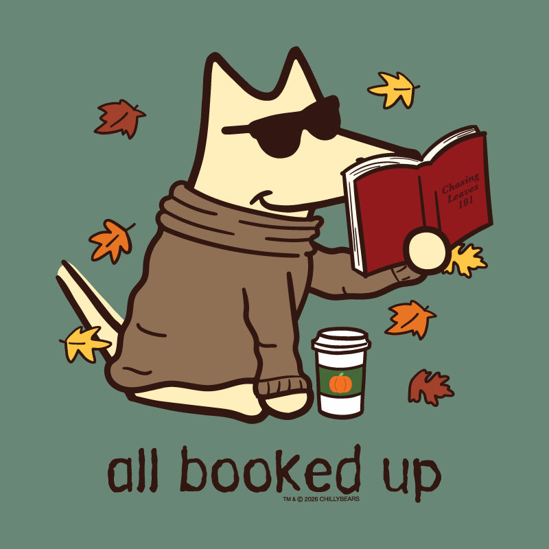A stylized cartoon fox wearing dark sunglasses, a brown sweater, and a scarf, sitting and reading an open red book. Yellow and orange autumn leaves float around it, with a takeaway coffee cup and the text 'all booked up' below on a muted green background.