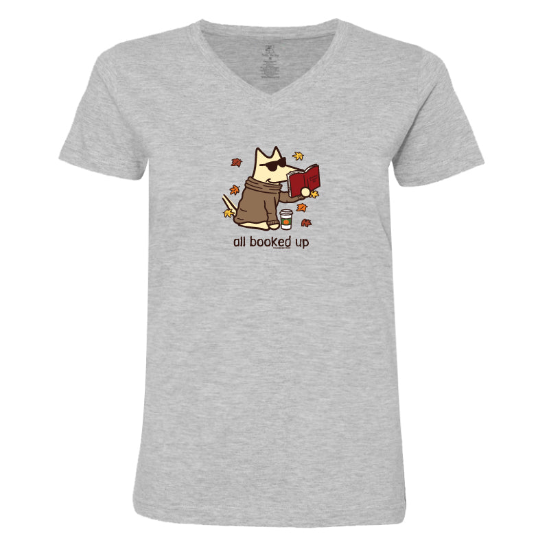 A light heather gray V-neck t-shirt featuring a cartoon graphic of a dog in a brown robe reading a red book, surrounded by autumn leaves, with the text 'all booked up' printed below.