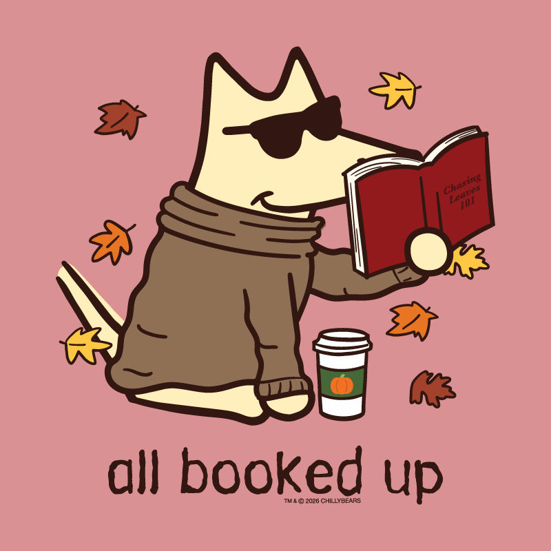 A stylized cartoon dog wearing dark sunglasses and a brown sweater sits on a dusty pink background, reading a red book with autumn leaves floating around it. A takeaway coffee cup appears beside the dog, and the text 'all booked up' appears below.