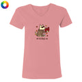 A pink V-neck t-shirt with a cartoon graphic of a dog wearing sunglasses and a trench coat while reading a red book, with the text 'all booked up' below. A small multicolor color wheel icon is in the top-left corner.