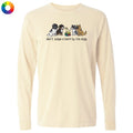 A cream-colored long-sleeve t-shirt with a graphic of four dogs and the text 'don't judge a bark by its size' printed on the chest. A small multicolor color wheel icon is visible in the top-left corner.