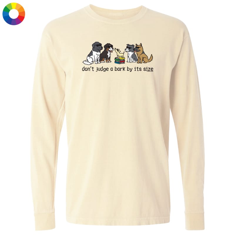 A cream-colored long-sleeve t-shirt with a graphic of four dogs and the text 'don't judge a bark by its size' printed on the chest. A small multicolor color wheel icon is visible in the top-left corner.