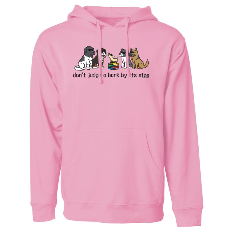 A pink pullover hoodie with a front graphic showing several cartoon dogs and the text 'don't judge a bark by its size' on a plain white background.
