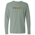 A sage green long-sleeve t-shirt with a horizontal line of small autumn-themed icons printed across the chest, including a paw print, maple leaf, dog, pumpkin, and sunflower.