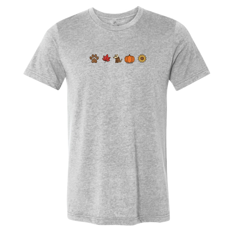 A heather gray short-sleeve crewneck t-shirt featuring a small horizontal graphic of autumn-themed icons (a paw print, a red maple leaf, a turkey, a pumpkin, and a sunflower) printed across the chest.