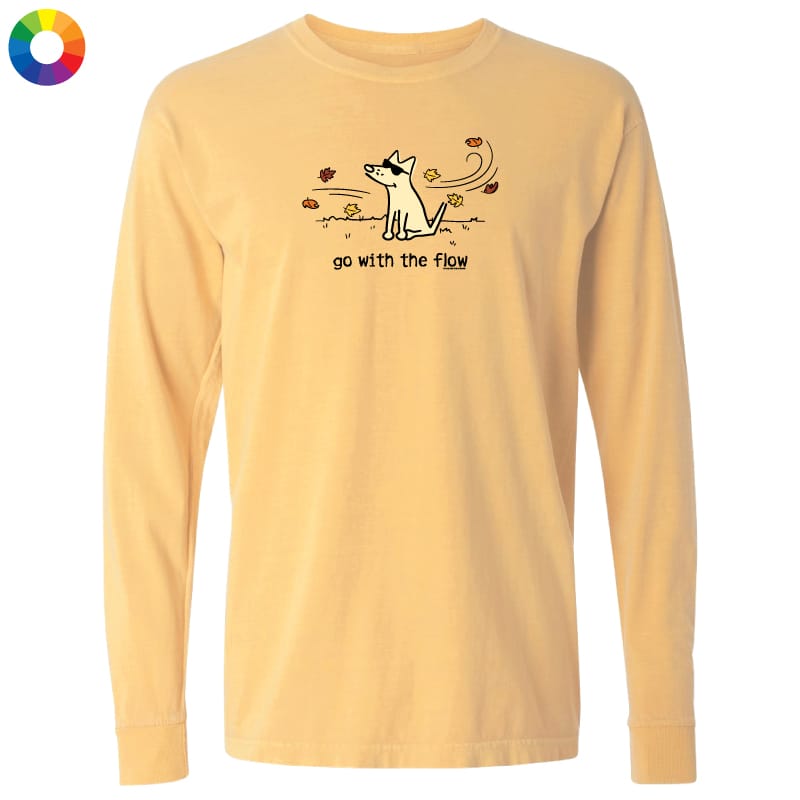 A pale yellow long-sleeve t-shirt with a cartoon dog graphic and the text 'go with the flow!' on the chest, displayed on a solid white background with a multicolor color wheel icon in the top-left corner.
