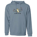 A dusty blue-gray pullover hoodie with a front graphic of a white dog sitting amidst autumn leaves, with the text 'go with the flow' printed below. The hoodie is shown against a plain white background.