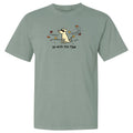 A sage green short-sleeve t-shirt with a graphic of a white dog looking up at flying leaves, with the text 'go with the flow' printed below.