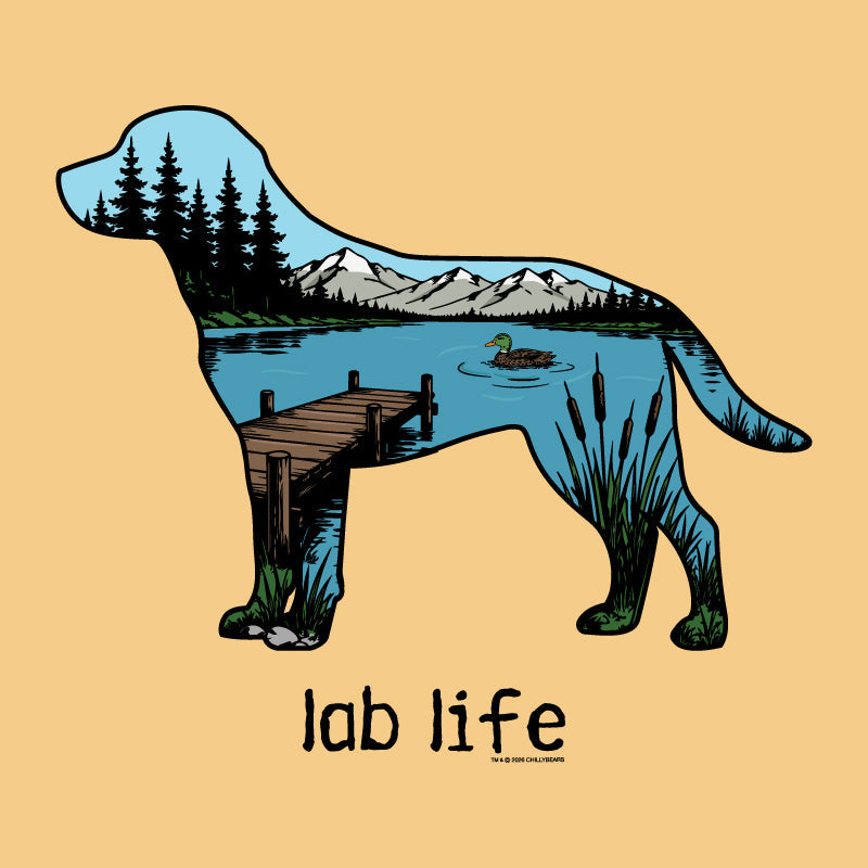 A stylized illustration of a dog silhouette filled with a lakeside mountain landscape, including pine trees, a dock, reeds, and a duck, on a warm beige background with the text 'lab life' below.
