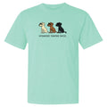 A mint green short-sleeve t-shirt with a graphic of three cartoon dogs in cream, brown, and black, with the text 'untoasted. toasted.