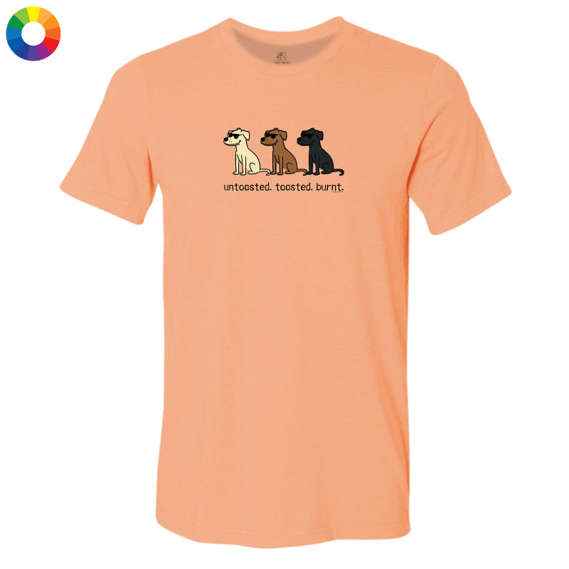 A peach-colored short-sleeve t-shirt with a graphic of three dogs and the text 'untasted. toasted burnt.