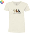 A women's short-sleeve V-neck t-shirt in a light heathered cream color, featuring a graphic of three dogs (Beagle, Labrador, and Rottweiler) with the text 'untoasted, toasted, burnt.' underneath.