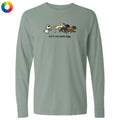 A sage green long-sleeve t-shirt with a graphic of a cat chasing three dogs and the text 'let's run some k9s' printed on the chest, displayed on a clean white background.