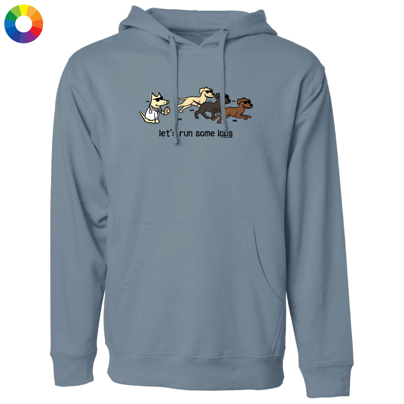 A dusty blue-gray pullover hoodie with a graphic of three cartoon dogs running and the text 'let's run some dogs' printed on the chest. The hoodie is shown against a plain white background, with a small multicolor color wheel icon in the top-left corner.