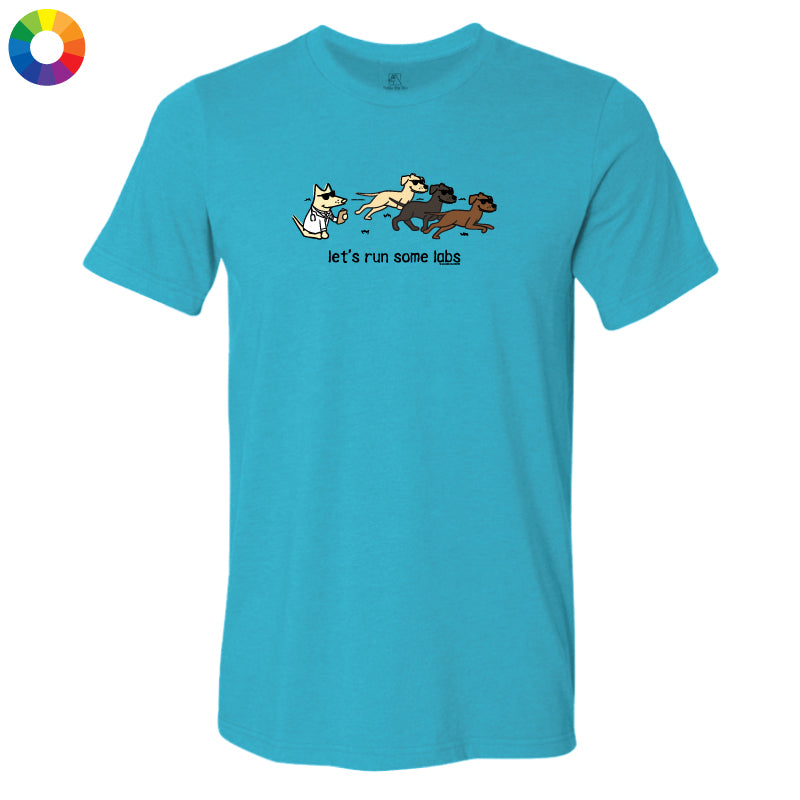 A bright turquoise blue short-sleeve t-shirt with a graphic of four dogs running and the text 'let's run some labs' printed on the chest, displayed on a clean white background.