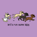 A purple graphic print featuring three cartoon dogs wearing sunglasses running, with a white dog on the left in a lab coat holding a bottle. Below the dogs, the text reads 'let's run some labs' in black lowercase letters.