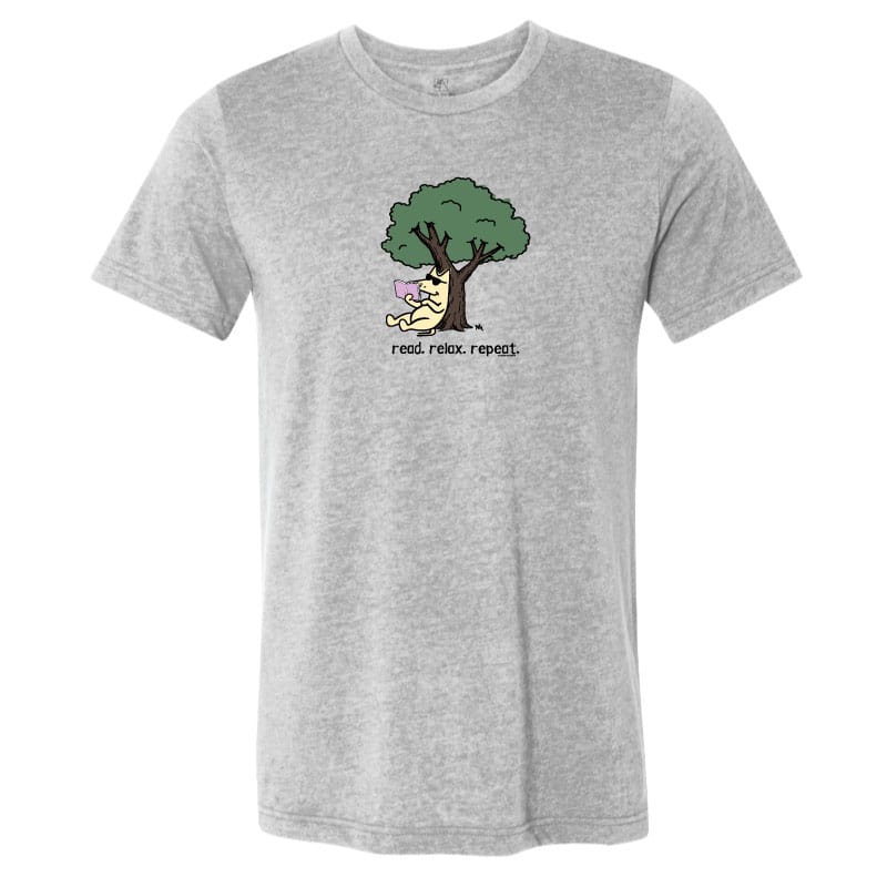 A heather gray short-sleeve crewneck t-shirt featuring a cartoon graphic of a yellow cat sitting under a green tree with the text 'read relax repeat.' printed below it.