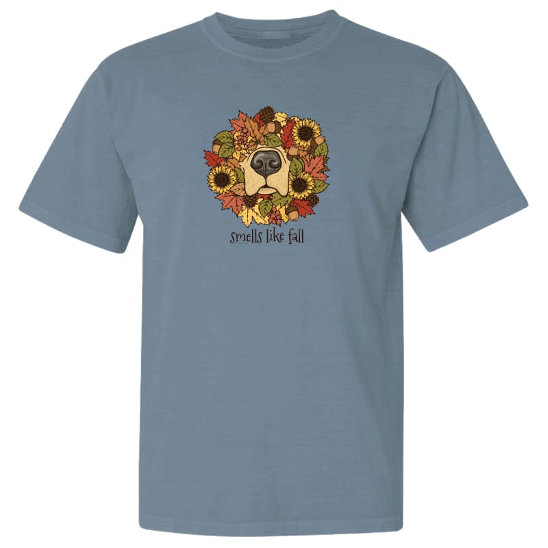 A heathered slate blue short-sleeve t-shirt with a graphic of a dog's face surrounded by autumn leaves and sunflowers, with the text 'smells like fall' printed below.