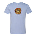 A light blue heather crewneck t-shirt featuring a graphic of a dog's face surrounded by autumn leaves and sunflowers, with the text 'smells like fall' printed below.