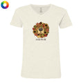 An off-white heathered v-neck t-shirt featuring a graphic of a dog's face surrounded by autumn leaves and sunflowers, with the text 'smells like fall' underneath. A small multicolor color wheel icon is visible in the top-left corner.