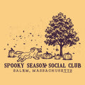A square graphic print with a warm peach background and dark purple line art. The illustration shows a large tree, several pumpkins, falling leaves, and a running dog.