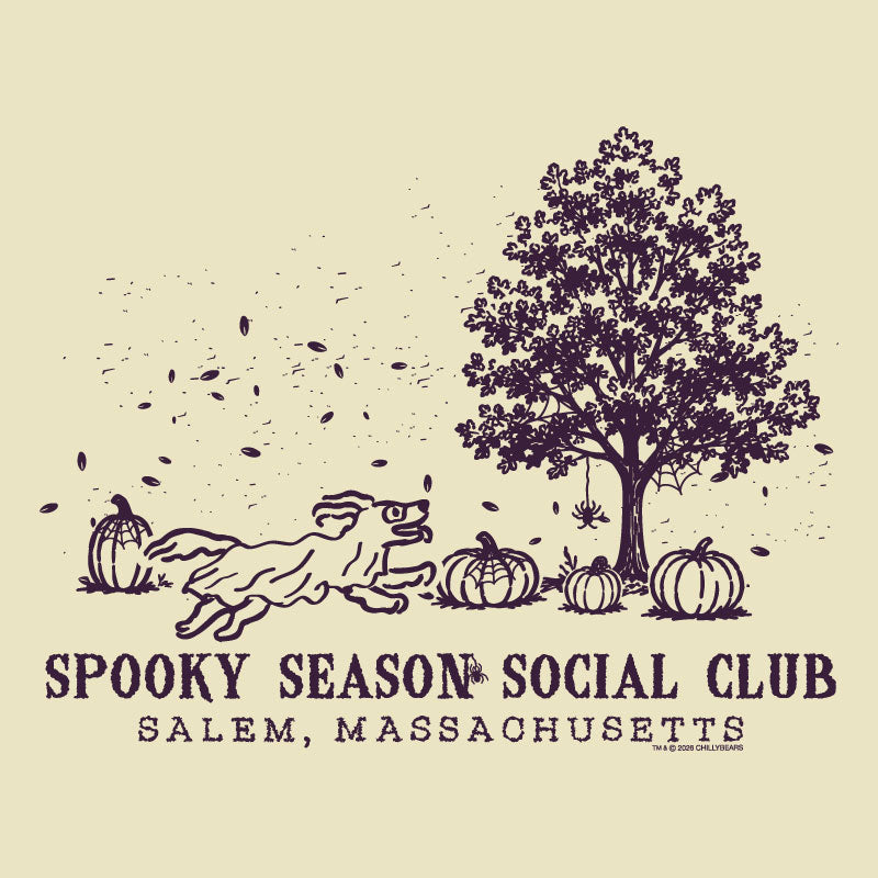 A vintage-style illustrated graphic on a warm cream background, featuring a dark purple line drawing of a tree, pumpkins, falling leaves, and a running dog. Text below reads 'SPOOKY SEASON SOCIAL CLUB' and 'SALEM, MASSACHUSETTS'.