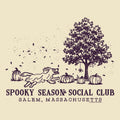 A vintage-style illustrated graphic on a warm cream background featuring a dark purple line drawing of a tree, pumpkins, falling leaves, and a running dog. Text below reads “SPOOKY SEASON SOCIAL CLUB” and “SALEM, MASSACHUSETTS.