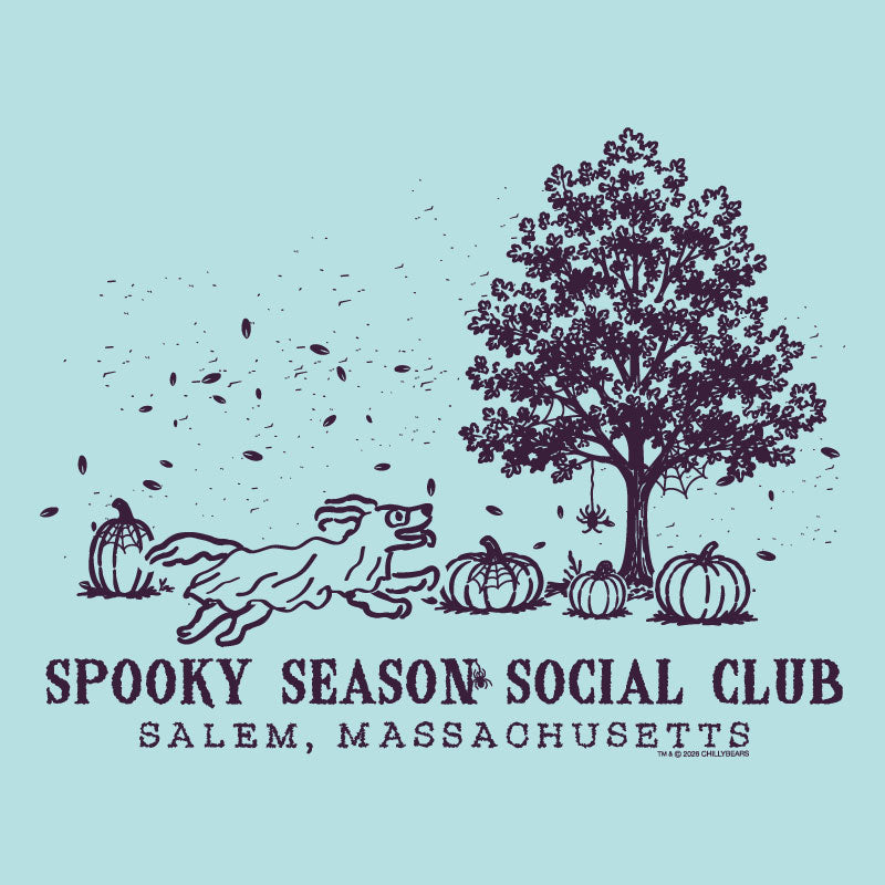 A light blue graphic print featuring a dark purple illustration of a running dog, pumpkins, a tree, and falling leaves, with the text 'SPOOKY SEASON SOCIAL CLUB' and 'SALEM, MASSACHUSETTS' below.