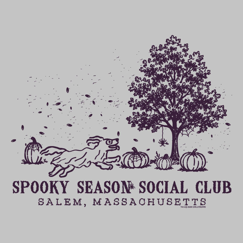 A dark purple Halloween-themed graphic on a light gray background, featuring a running dog, pumpkins, a tree, spiderwebs, and the text 'SPOOKY SEASON SOCIAL CLUB' and 'SALEM, MASSACHUSETTS'.