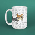 White mug with cartoon dogs and 'start to finnish' text on a green background