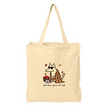 A beige canvas tote bag with a printed graphic of a dog wearing sunglasses and a plaid blanket, next to a basket of red apples, with the text 'the dog days of Fall' below.