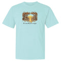 A light aqua blue short-sleeve crewneck t-shirt featuring a central graphic of a yellow dog sitting in a forest of falling leaves with the text 'The Cactus They Eat or Choke' printed below.