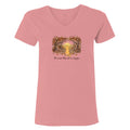 A pink short-sleeve V-neck t-shirt with a central graphic of a yellow dog sitting in a forest with the text 'The dogs they are a family' printed below it, shown on a plain white background.